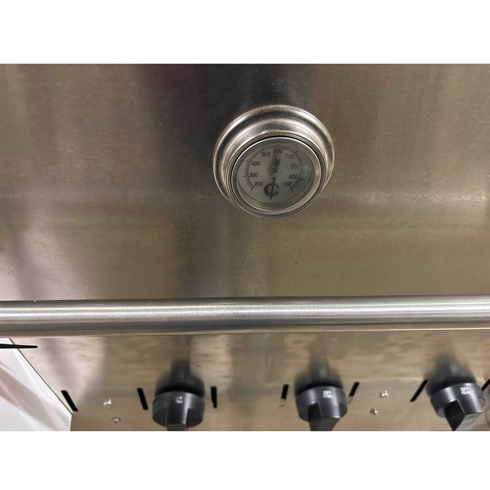 Stainless steel appliance with a temperature gauge and control knobs.