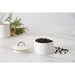 A white small canister with a diamond-quilted pattern and a matching lid, accented with gold trim, shown on a white marble surface with coffee beans scattered nearby.