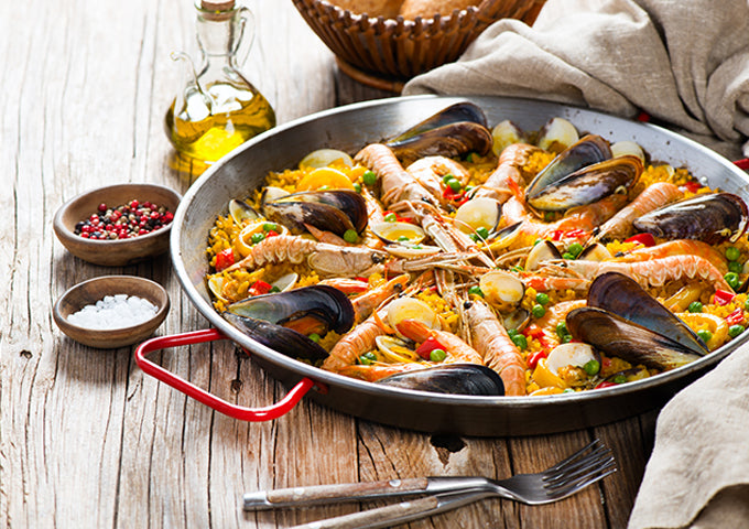 Winco CSPP-14 14" Polished Carbon Steel Paella Pan with Red Handles